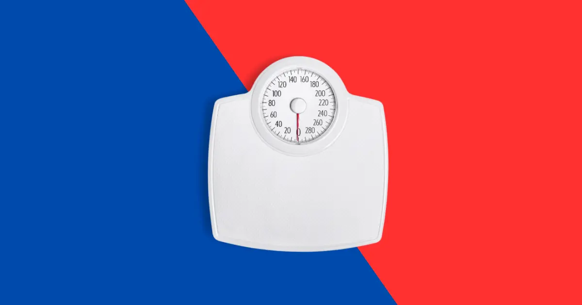 A white analog bathroom scale is centered on a blue and red split background. The scale’s dial shows numbers in pounds, sparking curiosity about common health myths like does masturbation cause weight loss?.