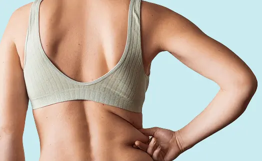 Woman pinching excess fat on body